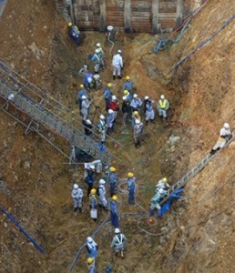 関西電力大飯原発の南側に掘られたトレンチ（溝）で調査する専門家チームら=7月27日、福井県おおい町