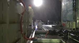 福島第１原発で汚染水貯留タンクの堰（せき）内にたまった水を移送する作業員=10月16日、東京電力撮影