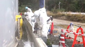 福島第1原発　タンクエリアの雨水対策。堰に鉄板を取り付け、かさ上げする作業員=10月25日、東京電力撮影