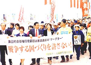浜川、春名、谷崎の各氏も横断幕をもってデモ行進しました＝24日、高知市