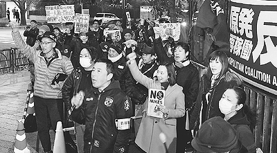 （写真）「原発なくせ」「再稼働反対」と唱和する人たち。中央右は吉良よし子参院議員＝3月６日、首相官邸前