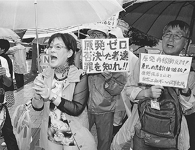 （写真）「すべての原発再稼働反対」とコールする人たち＝６月26日、首相官邸前