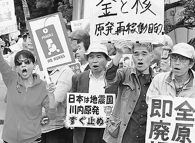 （写真）「川内原発いますぐ止めろ」と抗議のコールをする人たち＝5月20 日、首相官邸前