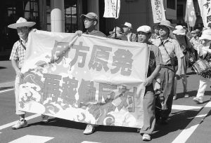 （写真）町役場前をデモ行進する人々＝8月11日、愛媛県伊方町
