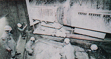 床に積もったナトリウム化合物を調べる職員ら（上部は焼損したダクト配管）＝1995年12月12日、福井県敦賀市の「もんじゅ」二次冷却系配管室